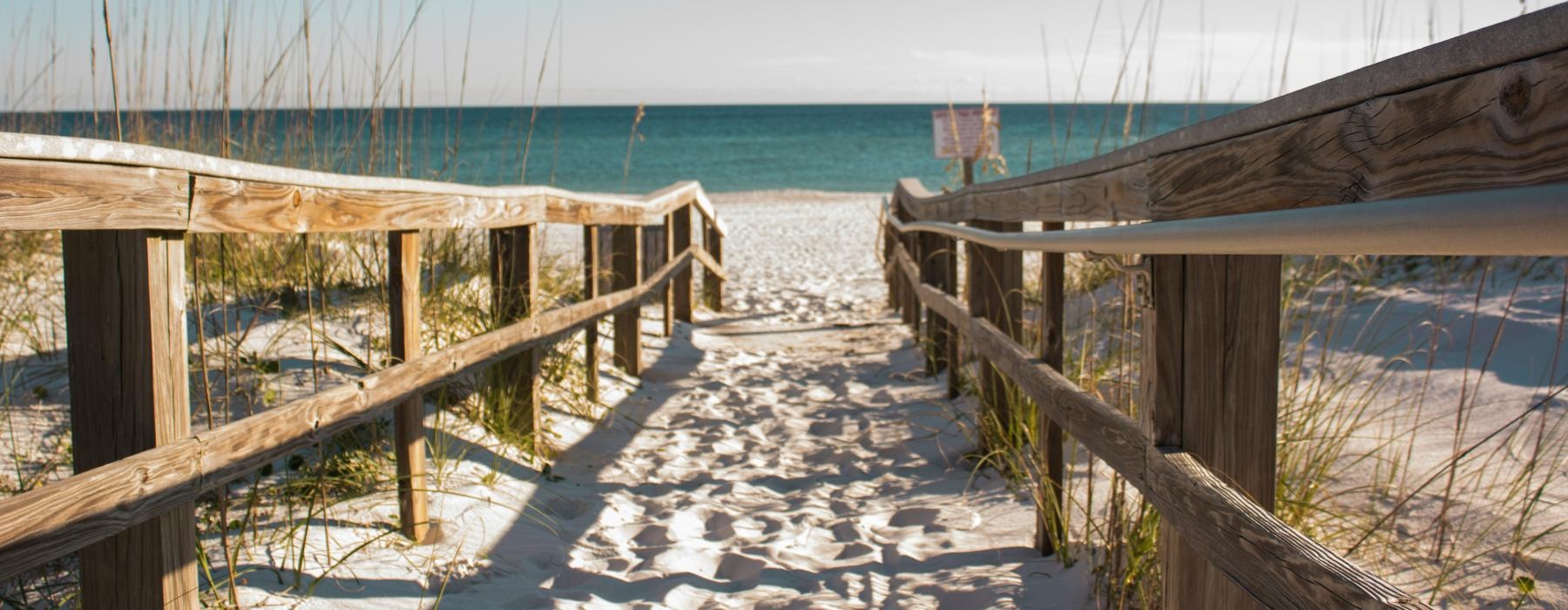 a wooden walkway to a beach